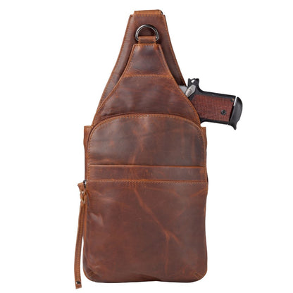 Brown leather sling bag with a gun inside on a white background