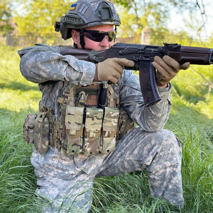 Person in military gear holding a rifle in an outdoor setting