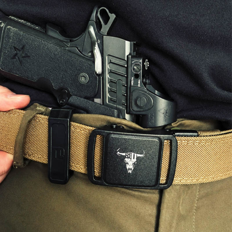 Close-up of a gun in a holster on a person's belt with a tactical belt.